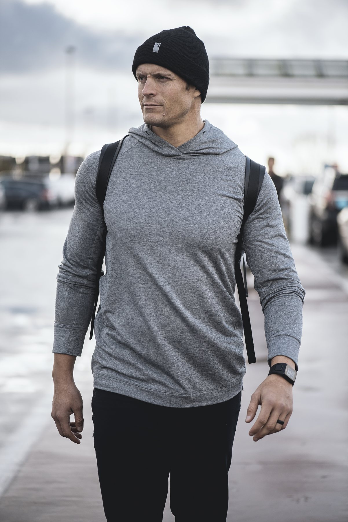 Dai Manuel standing on a Vancouver dock in a grey hoodie and beanie on an overcast morning
